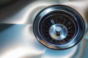 Close-up of a sink drain and garbage disposal, representing sink services in Topeka Lawrence, KS.